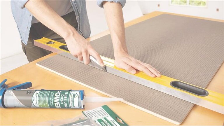 Person schneidet Dämmplatte mit Cuttermesser.